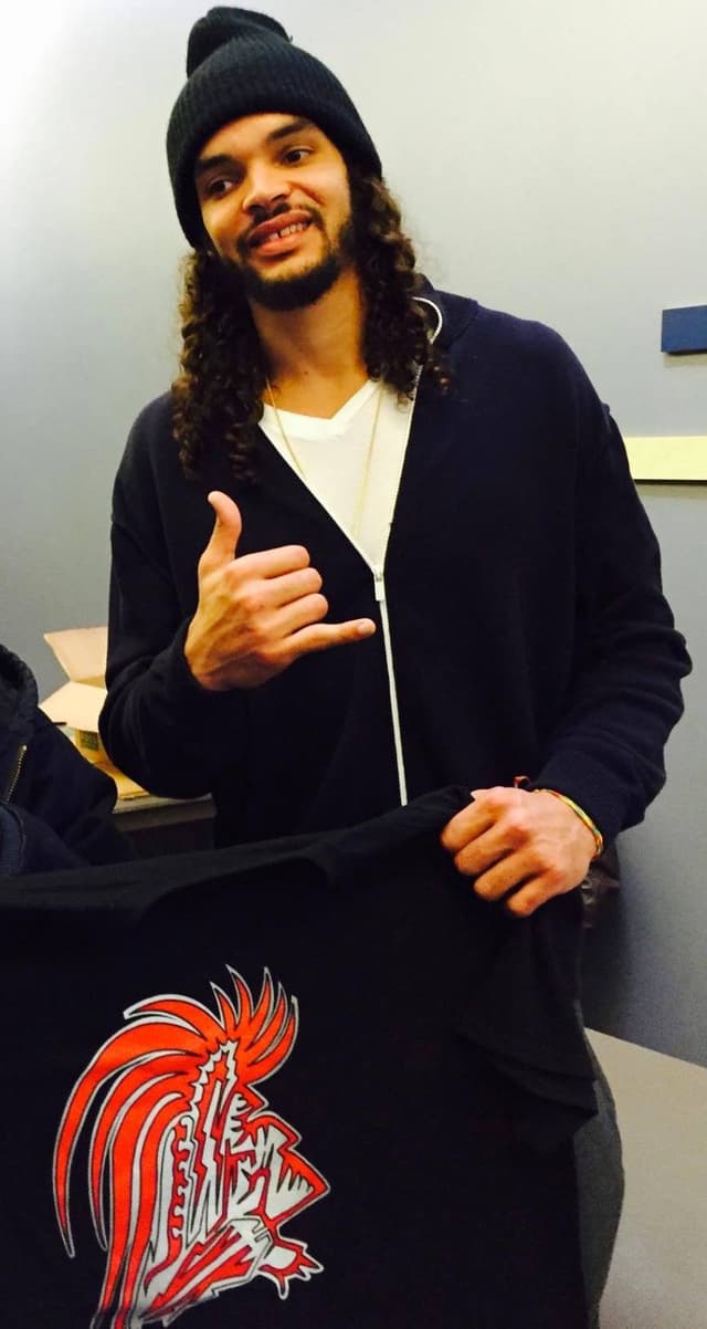 Joakim Noah holding a Unique Warrior shirt