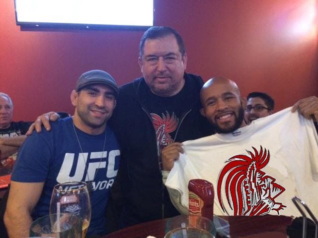 Ricardo Lamas and Demetrious Johnson holding Unique Warrior shirt